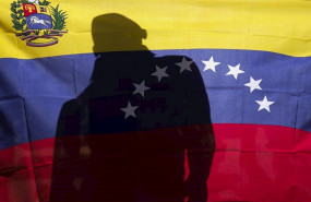 ep un hombre detras de una bandera de venezuela durante una protesta contra nicolas maduro