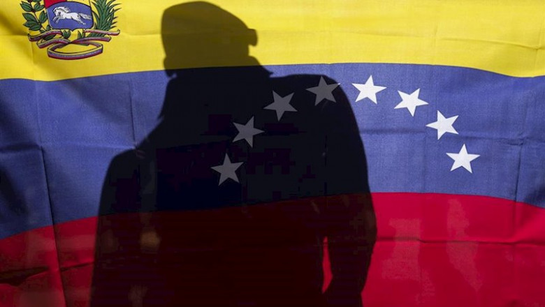 Un hombre detrás de una bandera de Venezuela durante una protesta contra Nicolás Maduro | Ringo Chiu/ZUMA Wire/dpa - Archivo ep un hombre detras de una bandera de venezuela durante una protesta contra nicolas maduro