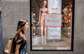 ep archivo   una mujer pasa por el escaparate de una tienda