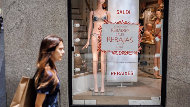 ep archivo   una mujer pasa por el escaparate de una tienda