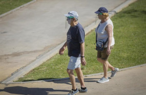 ep dos personas con ropa veraniega y gorra pasean por el parque del alamillo en sevilla andalucia