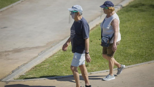 ep dos personas con ropa veraniega y gorra pasean por el parque del alamillo en sevilla andalucia