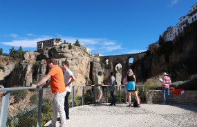 ep turistas observan el tajo de ronda desde un mirador