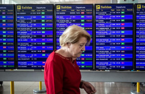 ep una mujer pasa frente al panel de infromacion de los vuelos de salida del aeropuerto josep