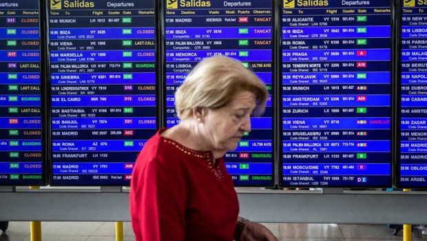ep una mujer pasa frente al panel de infromacion de los vuelos de salida del aeropuerto josep