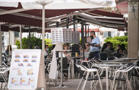 ep un camarero atiende una mesa en la terraza de una cafeteria