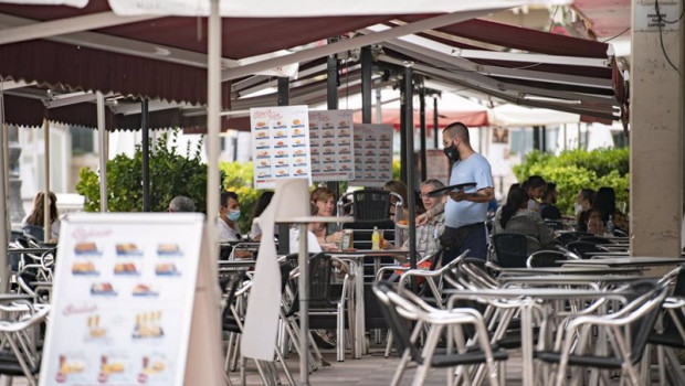 ep un camarero atiende una mesa en la terraza de una cafeteria