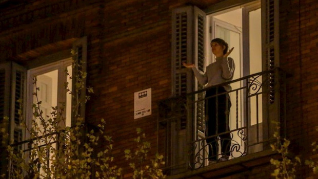 ep una mujer aplaude desde su balcon por la labor que estan realizando los sanitarios ante la crisis