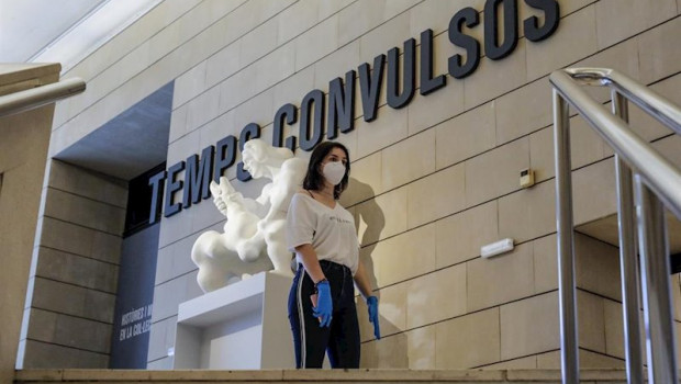 ep una mujer protegida con guantes y mascarilla a la entrada de una exposicion en el museo institut