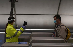 ep una voluntaria de la dya toma la temperatura con una pistola a un viajero en la estacion de metro