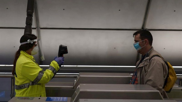 ep una voluntaria de la dya toma la temperatura con una pistola a un viajero en la estacion de metro