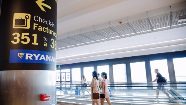 ep archivo   dos mujeres caminan al lado de un cartel indicativo de los mostradores de ryanair en el
