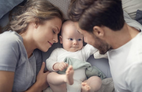 ep imagen de una pareja de padres con el bebe en la cama