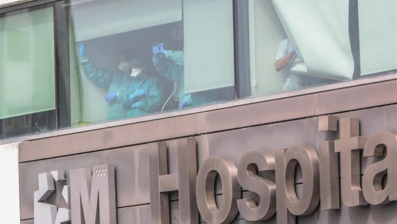 Sanitarios del Hospital de La Paz totalmente protegidos saludan y agradecen el apoyo desde una de las ventanas del centro donde se lucha contra el coronavirus, en Madrid. | Jesús Hellín - Europa Press ep sanitarios del hospital de la paz totalmente protegidos saludan y agradecen el apoyo desde una de