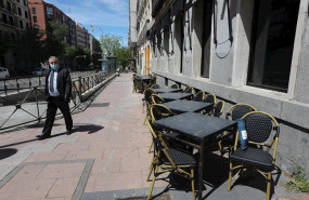 ep un hombre con mascarilla pasa junto a una terraza cerrada de un bar en madrid un dia despues de