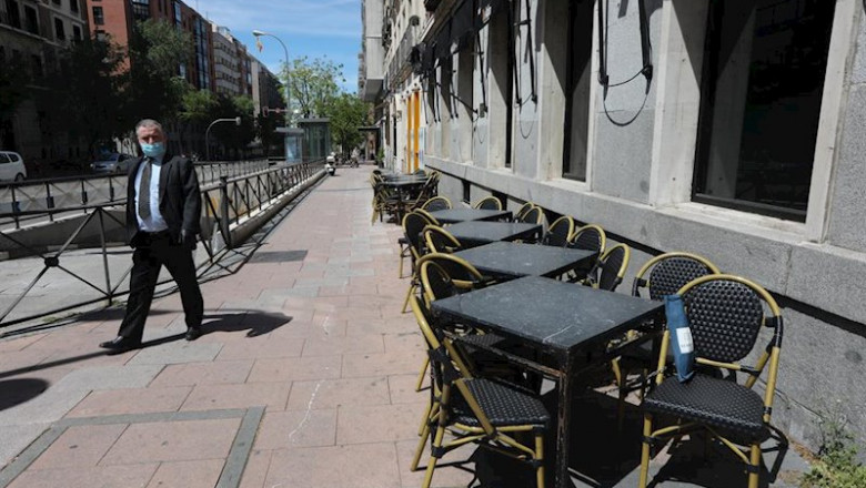 ep un hombre con mascarilla pasa junto a una terraza cerrada de un bar en madrid un dia despues de