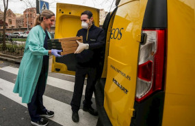 ep una trabajadora sanitaria de la clinica ruber recoge las pizzas que le ha llevado un repartidor