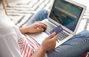 ep archivo   viajero usando un portatil con una tarjeta de credito en la mano