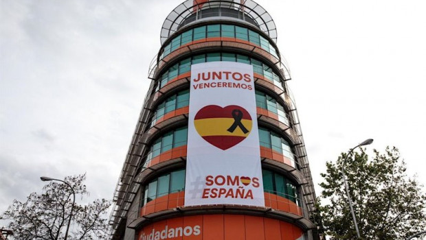 ep ciudadanos despliega una lona con un crespon negro junto a la bandera de espana en su sede