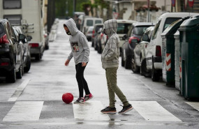 ep dos ninos protegidos con mascarilla juegan con una pelota por la calle en el primer dia de