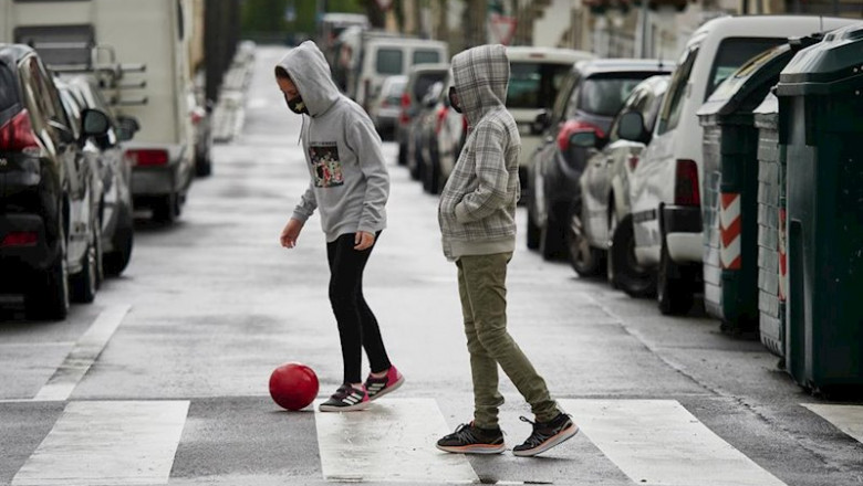 ep dos ninos protegidos con mascarilla juegan con una pelota por la calle en el primer dia de