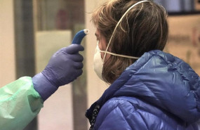 ep un sanitario toma la temperatura a una de los paciente diagnosticados con covid-19 en un centro