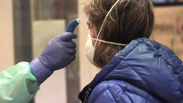 ep un sanitario toma la temperatura a una de los paciente diagnosticados con covid-19 en un centro