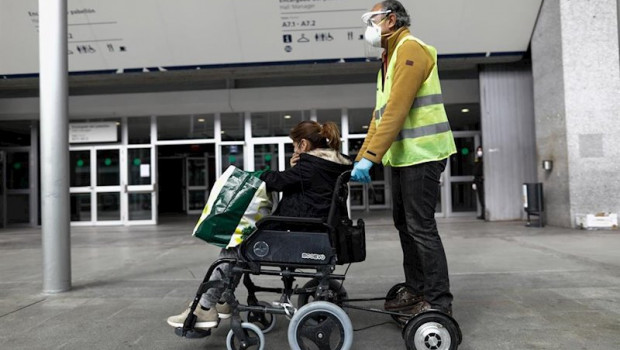 ep un trabajador sanitario protegido lleva en silla de ruedas al exterior del hospital de campana