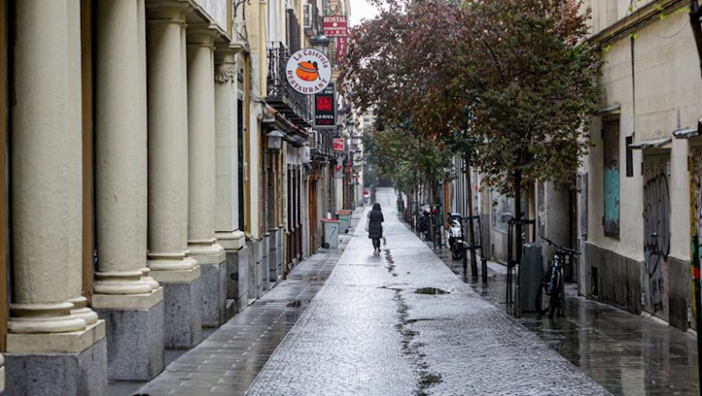 ep una persona camina por una calle de madrid vacia y con negocios cerrados durante el estado de