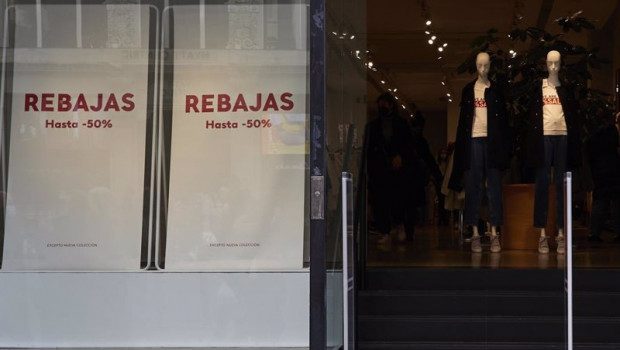 ep entrada de una tienda de ropa con carteles de rebajas en una calle comercial del centro de madrid