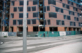 ep archivo   una persona pasa por delante de una fachada de ladrillos de una obra en construccion