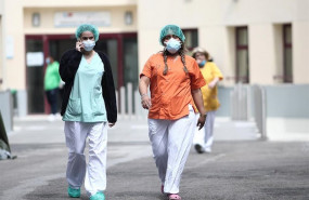 ep dos sanitarias protegidas con mascarilla y gorro caminan cerca del hospital de campana en las