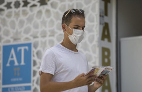 ep un turista lee una guia mientras pasea por el casco historico de sevilla andalucia espana a 27 de