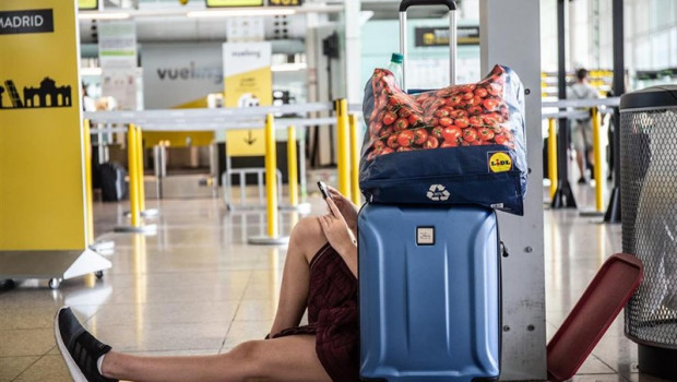 ep un joven miramovil sentadoamaleta juntopuestola compania vuelingaeropuerto josep tarradellas barcelona-prat durantehuelgapersonaltierraiberiabarcelona