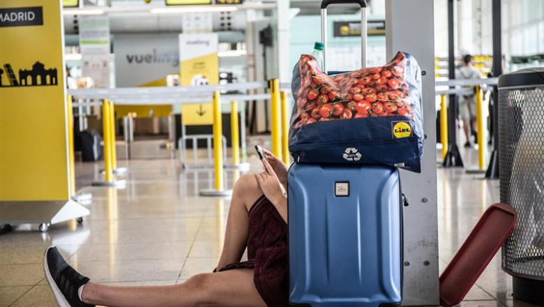 Un joven mira su movil sentado junto a su maleta, junto al puesto de la compañía, Vueling en el Aeropuerto 'Josep Tarradellas Barcelona-El Prat', durante la Huelga del personal de tierra de Iberia en Barcelona. | David Zorrakino - Europa Press ep un joven miramovil sentadoamaleta juntopuestola compania vuelingaeropuerto josep tarradellas barcelona-prat durantehuelgapersonaltierraiberiabarcelona