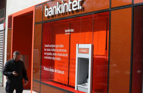 ep un hombre pasa al lado de un cajero del banco bankinter