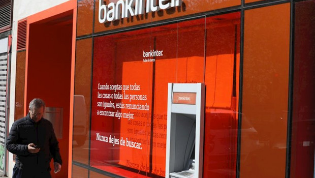 ep un hombre pasa al lado de un cajero del banco bankinter
