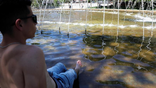 ep un joven moja sus piernas para refrescarse de las altas temperaturas en las inmediaciones de los