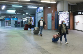 ep tres personas con maletas y protegidas con mascarillas en la estacion de atocha